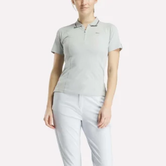 Polo de golf moulant à manches courtes et fermeture éclair pour femme
