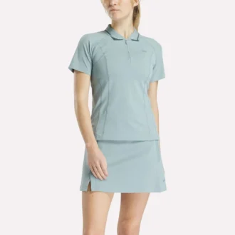 Polo de golf moulant à manches courtes et fermeture éclair pour femme