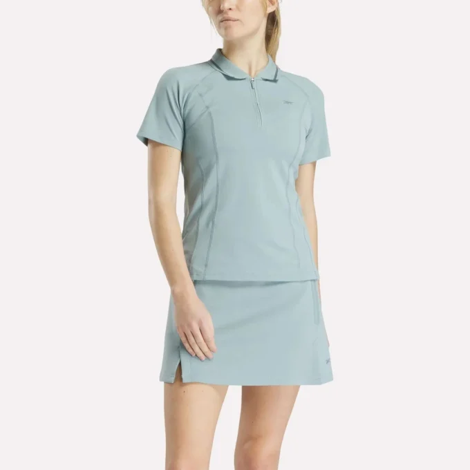 Polo de golf moulant à manches courtes et fermeture éclair pour femme