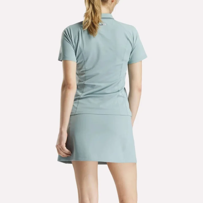 Polo de golf moulant à manches courtes et fermeture éclair pour femme
